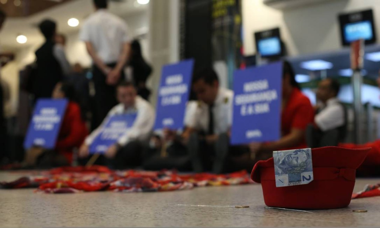 Sentados no saguão do aeroporto Santos Dumont, no Rio, os funcionários da aérea protestavam contra o atraso dos salários Foto: Pedro Teixeira / Agência O Globo