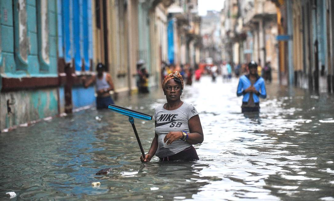 Cubanos andam por rua inundada em Havana após furacão: ritmo das mudanças climáticas preocupam o mundo Foto: YAMIL LAGE / AFP/10-9-2017