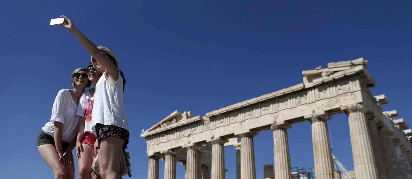 Grupo de turistas tira uma selfie em frente ao Parthenon, em Atenas Foto: Christian Hartmann / Reuters