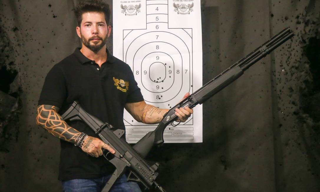 Axl Satier, dono da Nit Army, com duas armas. Ele diz que pretende abrir nova filial da rede que administra Foto: Marcelo Regua / Agência O Globo