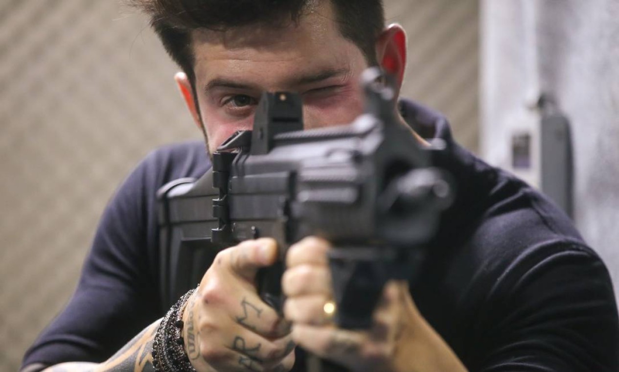 Na foto, Axl Satier, 37 anos, posa com uma arma de grosso calibre Foto: Marcelo Regua / Agência O Globo
