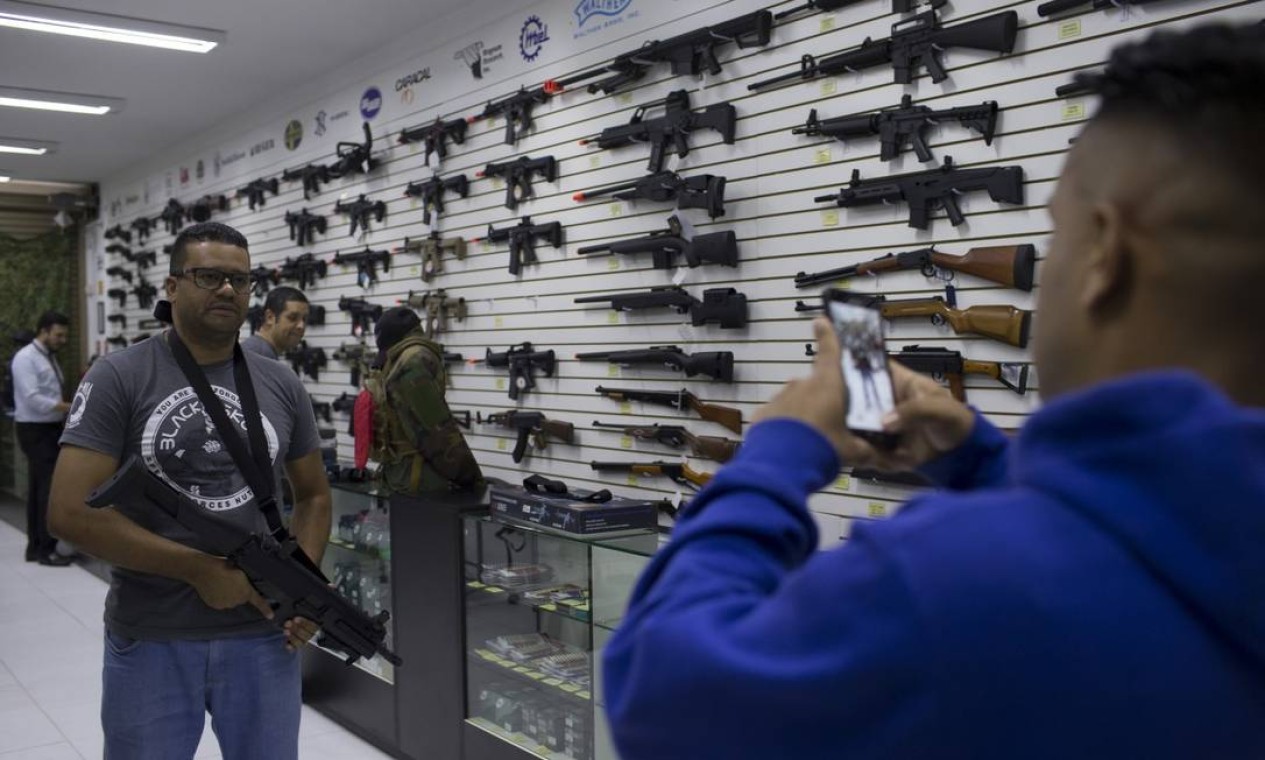 Clientes fazem foto com arma em loja de São Paulo. Na imagem, clientes na loja Top Arms, em São Paulo Foto: Edilson Dantas / Agência O Globo