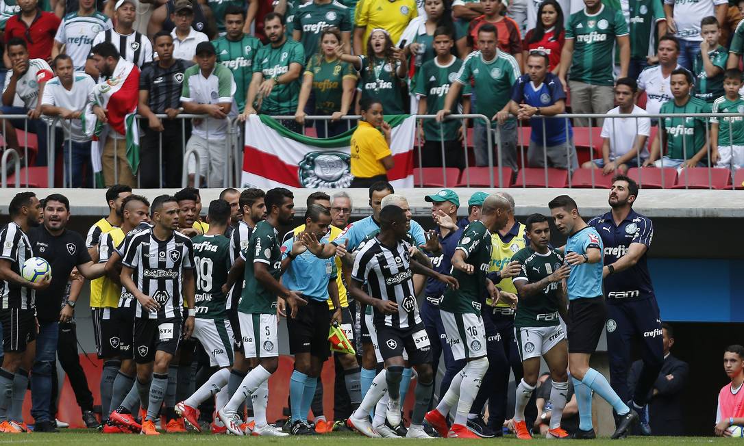 Jogadores de Botafogo e Palmeiras cercam arbitragem após a confusão na marcação de pênalti pelo VAR Foto: Jorge William