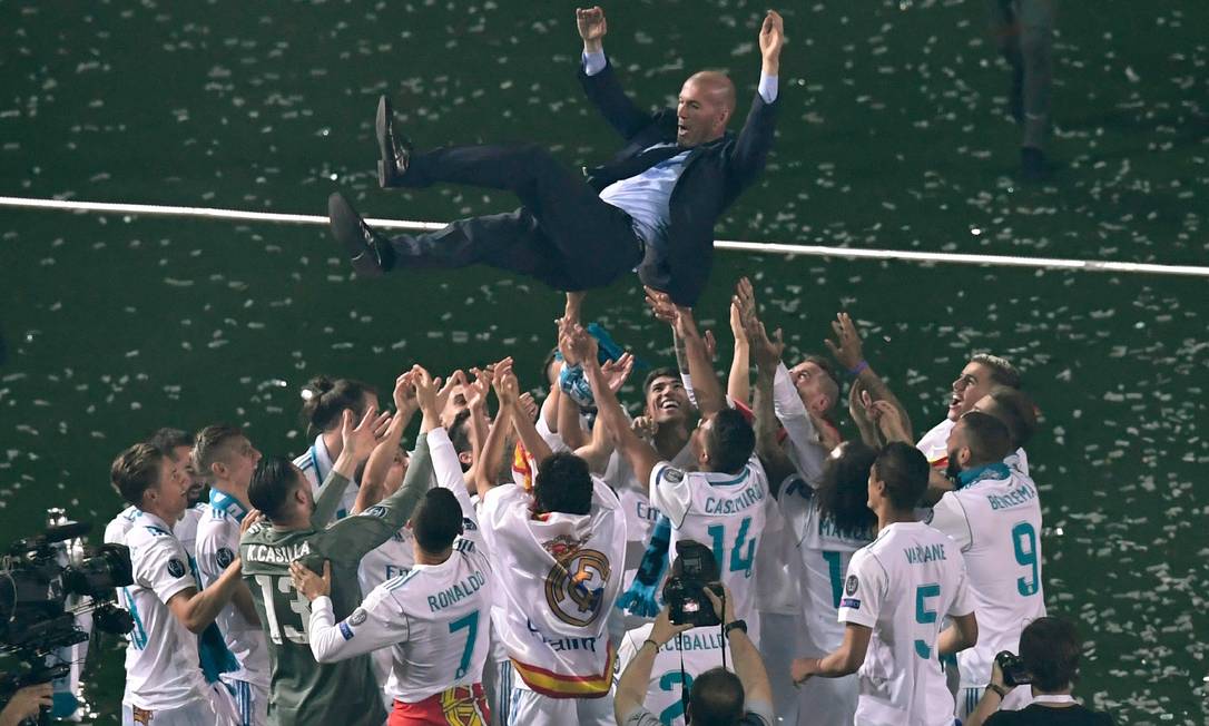 Time do Real Madrid comemora com o técnico Zinedine Zidane após conquistar o 13° título da Champions League Foto: GABRIEL BOUYS / AFP