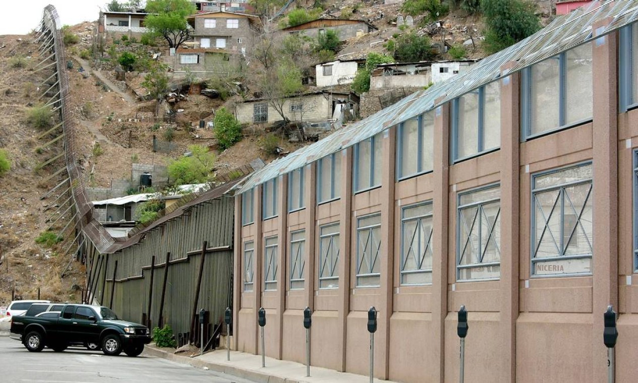 Muro separa as cidades de Nogales, Arizona, EUA (à esquerda) e Sonora, México (favela). Nesse ponto o muro novo, de concreto, pintado de cor-de-rosa, se encontra com o antigo, feito de placas de metal Foto: José Meirelles Passos / Divulgação