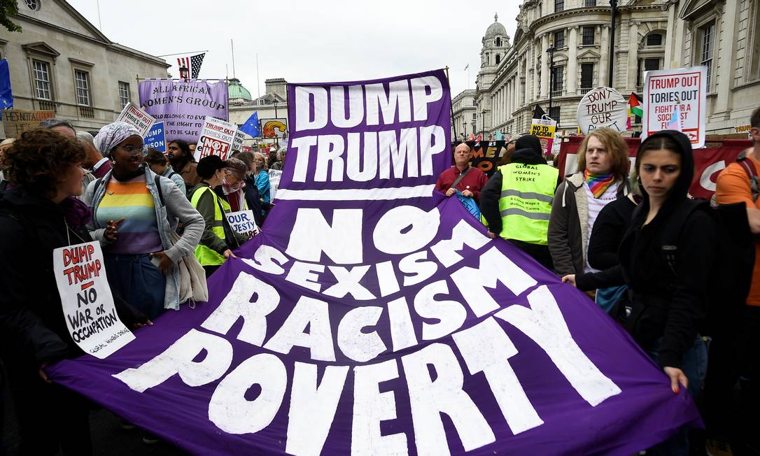 Manifestantes carregam faixas que dizem "descartem o Trump" e "Não ao sexismo, ao racismo e à pobreza" Foto: CLODAGH KILCOYNE / REUTERS