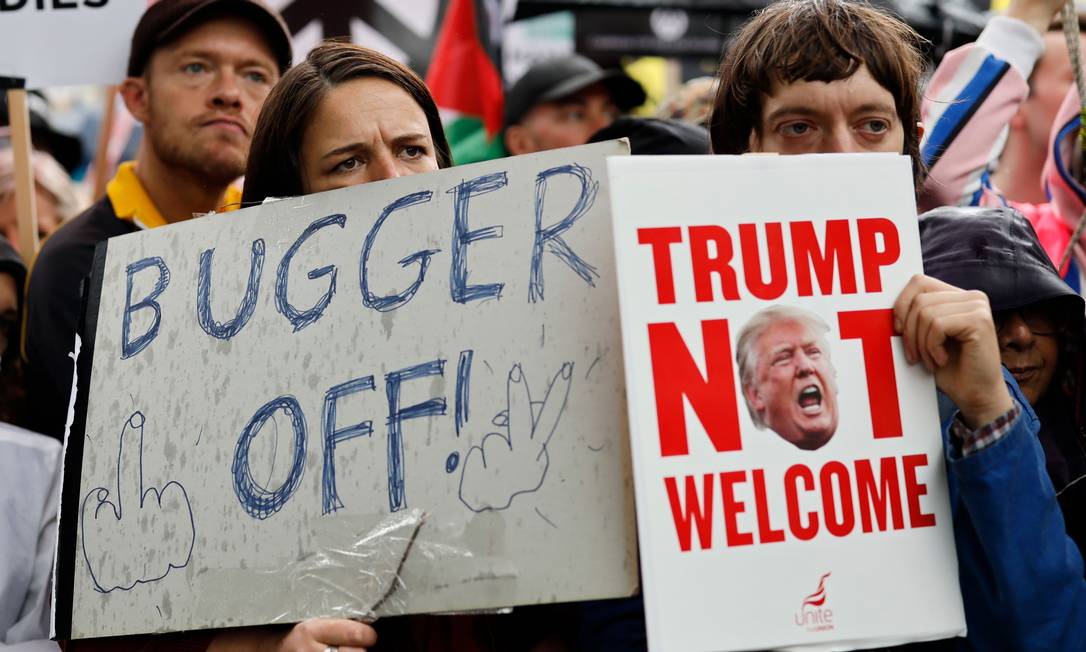 "Cai fora" e "Trump não é bem-vindo", dizem cartazes nos protestos contrários à visita do líder americano Foto: TOLGA AKMEN / AFP