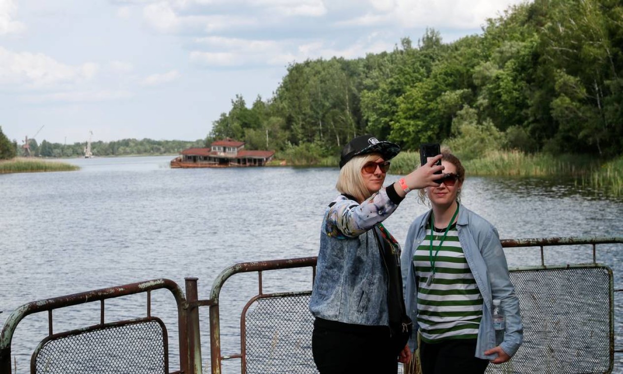 Visitantes tiram fotos numa ponte em Pripyat, perto de Chernobyl, no dia 2 de junho de 2019 Foto: VALENTYN OGIRENKO / REUTERS