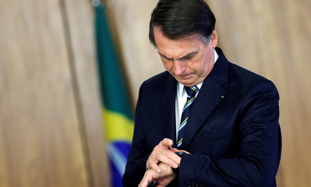 Bolsonaro confere o relógio durante cerimônia no Palácio do Planalto Foto: ADRIANO MACHADO / REUTERS