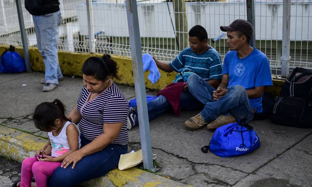 Imigrantes centro-americanos aguardam a resposta ao pedido de asilo ou visto humanitário na ponte entre Guatemala e México Foto: PEDRO PARDO / AFP
