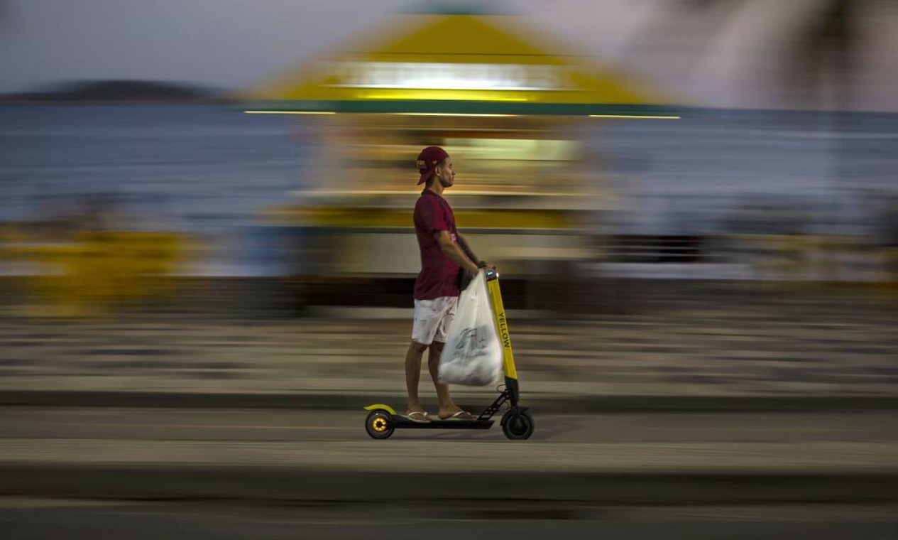 Com uma sacola, homem passeia de patinete em Ipanema Foto: Alexandre Cassiano / Agência O Globo