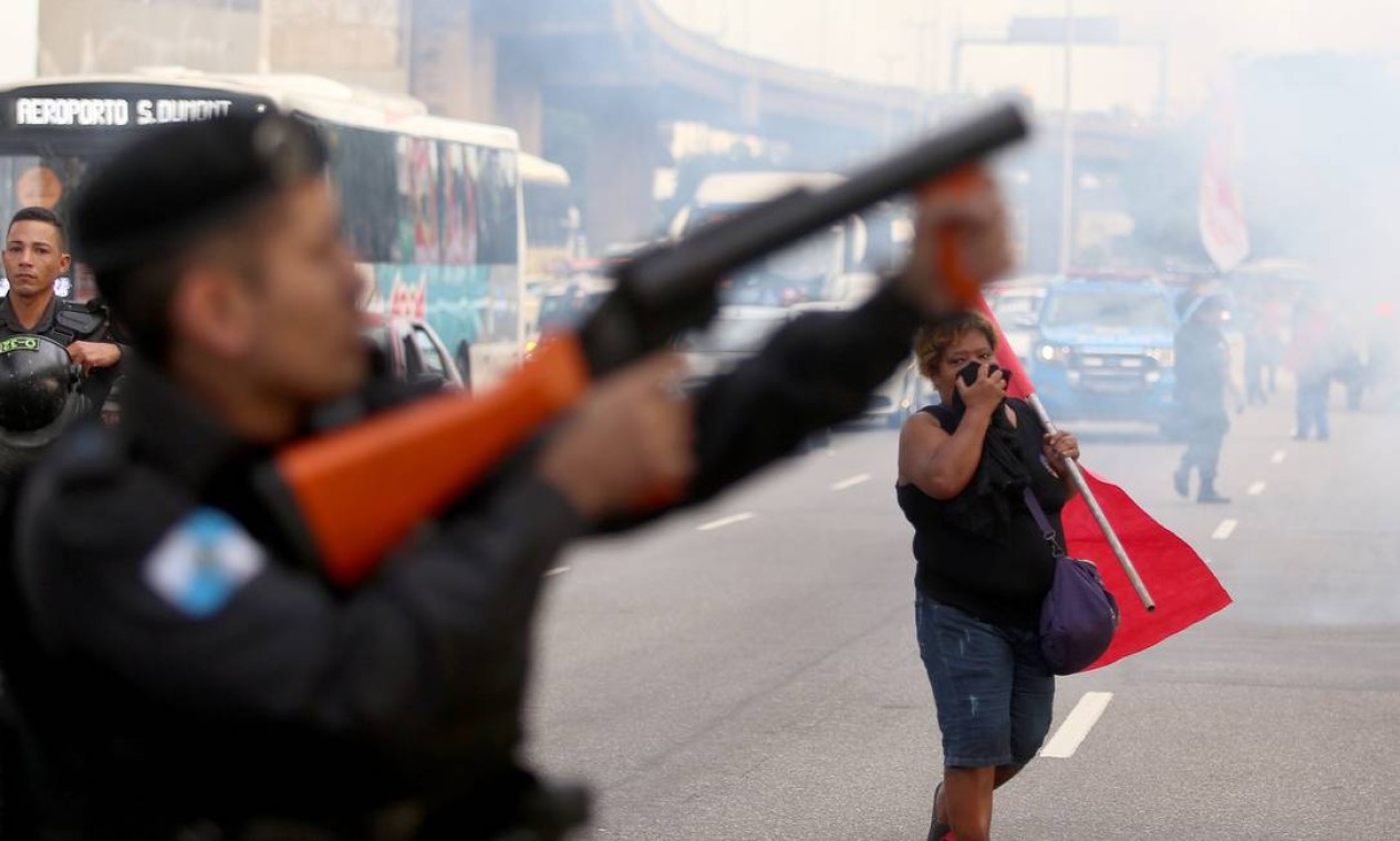 Policial lança bomba de efeito moral para dispersar manifestantes em frente ao Into, no Rio Foto: Fabiano Rocha / Agência O Globo