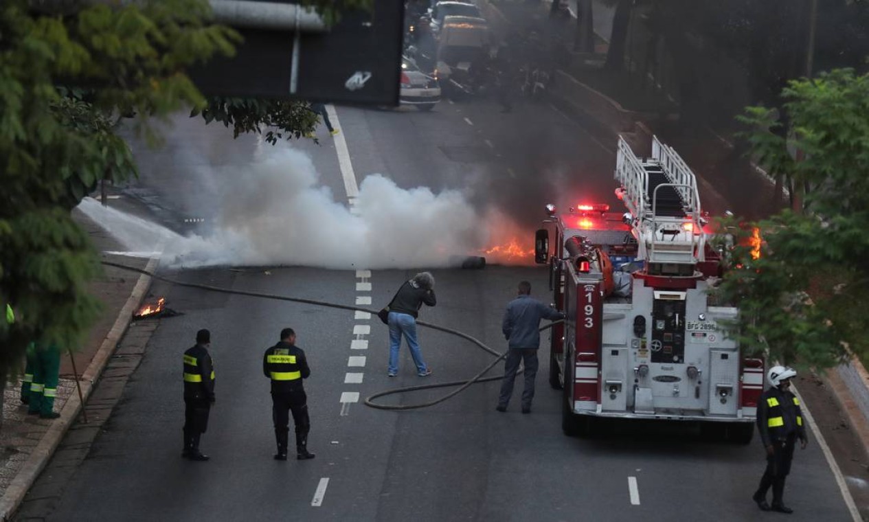 Bombeiros tentam apagar o fogo da queima de pneus que bloqueou uma rua no centro de São Paulo Foto: NACHO DOCE / Reuters