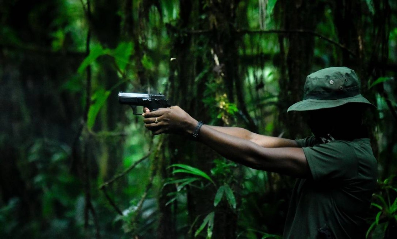 Integrante do Exército de Libertação Nacional pratica disparos com um revólver em uma região de mata fechada no departamento de Chocó, na Colômbia Foto: RAUL ARBOLEDA / AFP