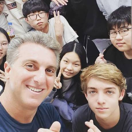 Huck posa com o filho e estudantes da Coreia do Sul Foto: Reprodução