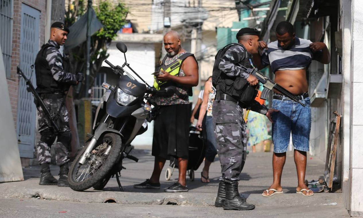Morador e mototaxista são revistados em um acesso ao Morro do Dendê Foto: Marcia Foletto / Agência O Globo