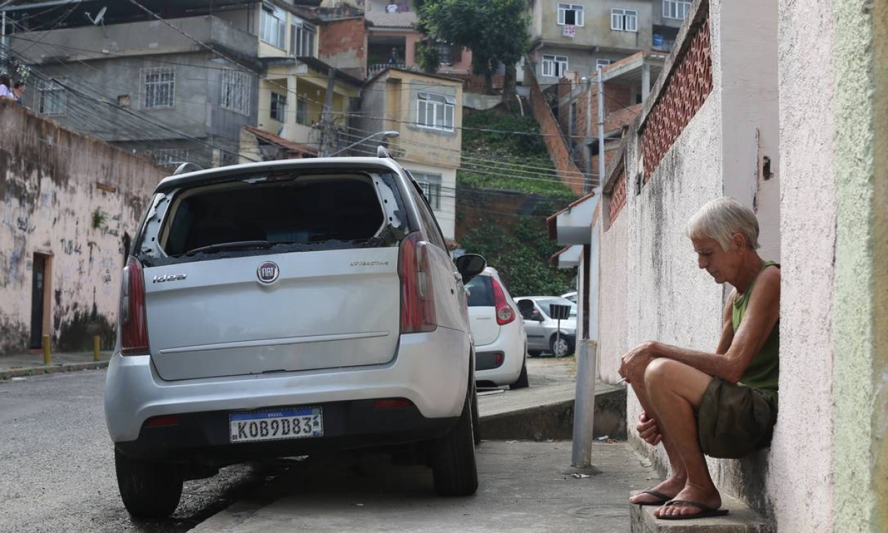 O vidro traseiro de um carro de morador é quebrado durante o tiroteio Foto: Marcia Foletto / Agência O Globo