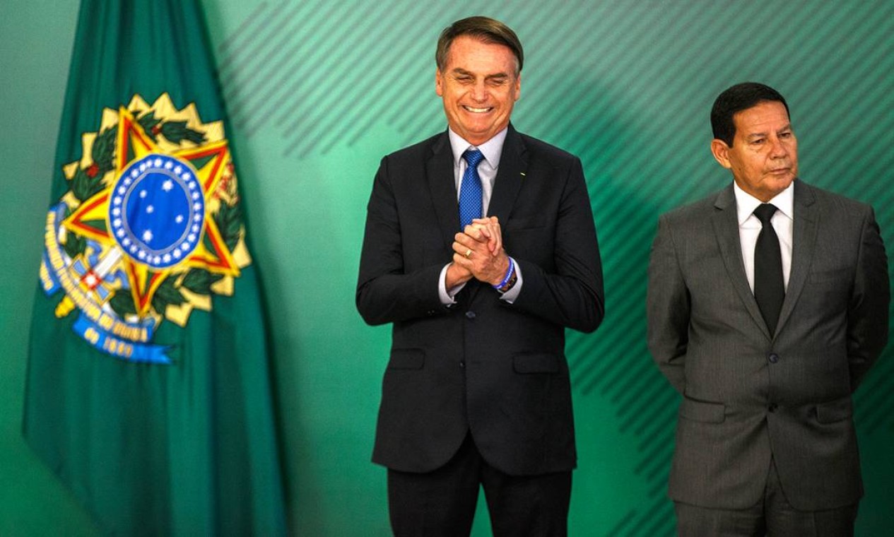 Bolsonaro durante cerimônia de assinatura da MP que visa coibir fraudes no INSS, ao lado do vice-presidente, general Hamilton Mourão Foto: Daniel Marenco / Agência O Globo