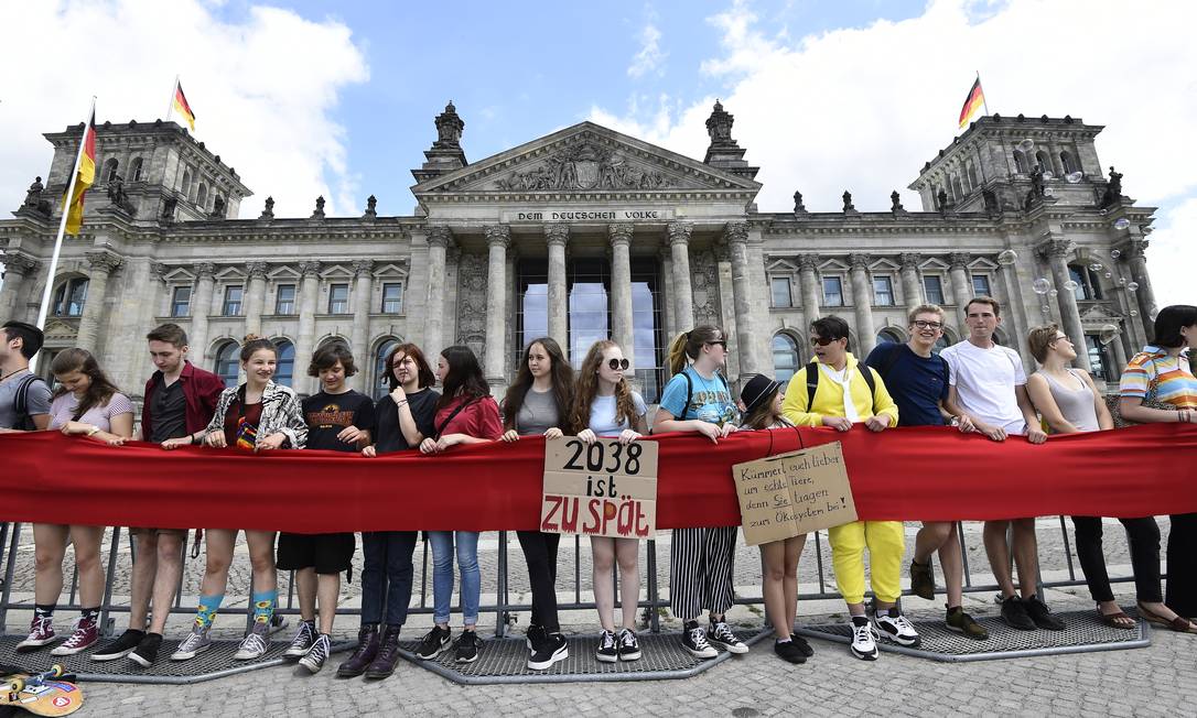 Jovens ativistas formam uma corrente humana em frente ao parlamento alemão para pressionar por medidas efetivas contra aquecimento global Foto: TOBIAS SCHWARZ / AFP