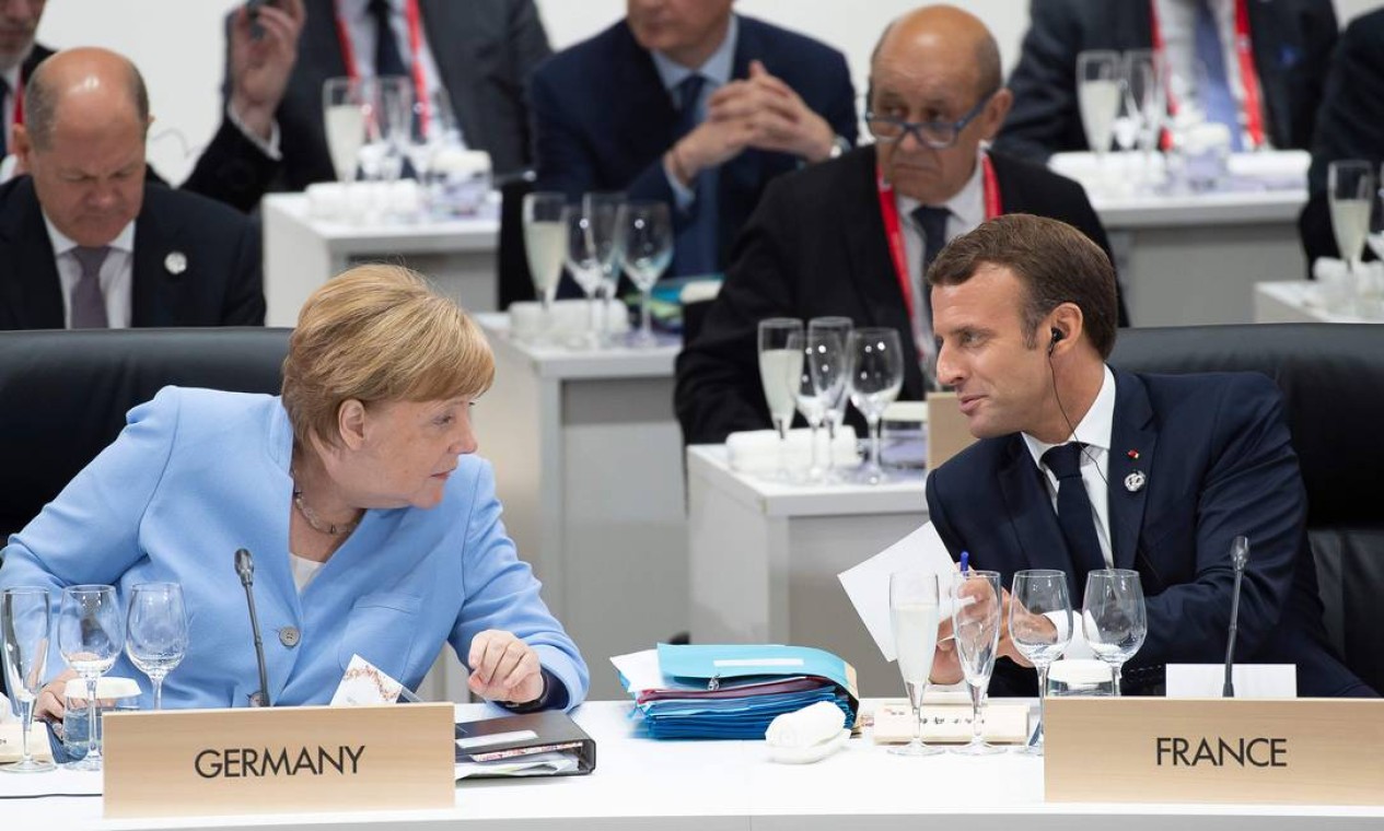 O presidente francês, Emmanuel Macron, conversa com a chanceler alemã, Angela Merkel, durante uma reunião sobre economia mundial Foto: ELIOT BLONDET / AFP