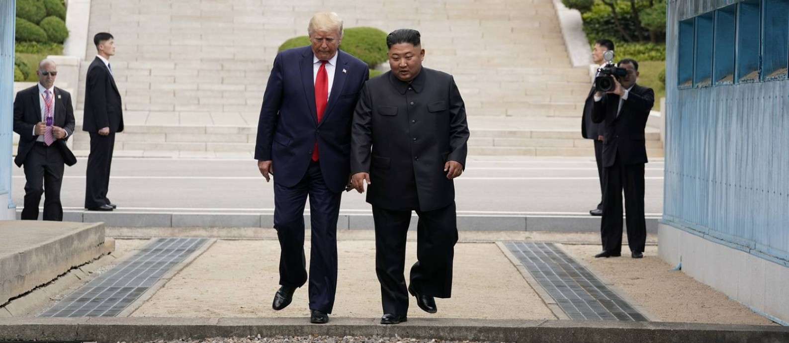 Momento em que Donald Trump cruza a fronteira entre as Coreias Foto: KEVIN LAMARQUE / REUTERS