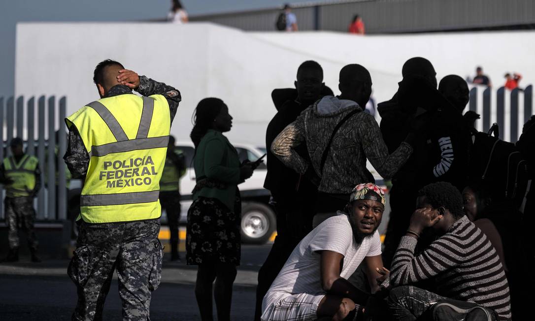 Solicitantes de asilo aguardam entrevista com autoridades de imigração dos Estados Unidos em frente ao porto de El Chaparral, em Tijuana, no México Foto: GUILLERMO ARIAS / AFP