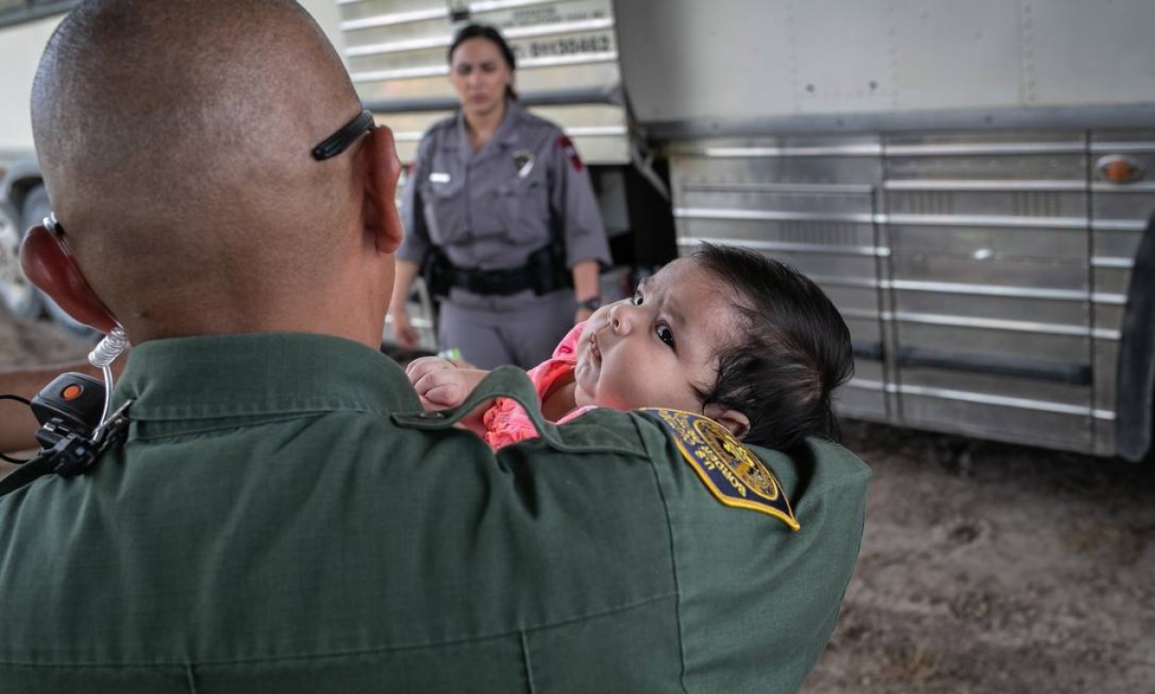 Agente da Patrulha da Fronteira dos EUA segura uma criança depois que ela e sua mãe foram levadas sob custódia Foto: JOHN MOORE / AFP