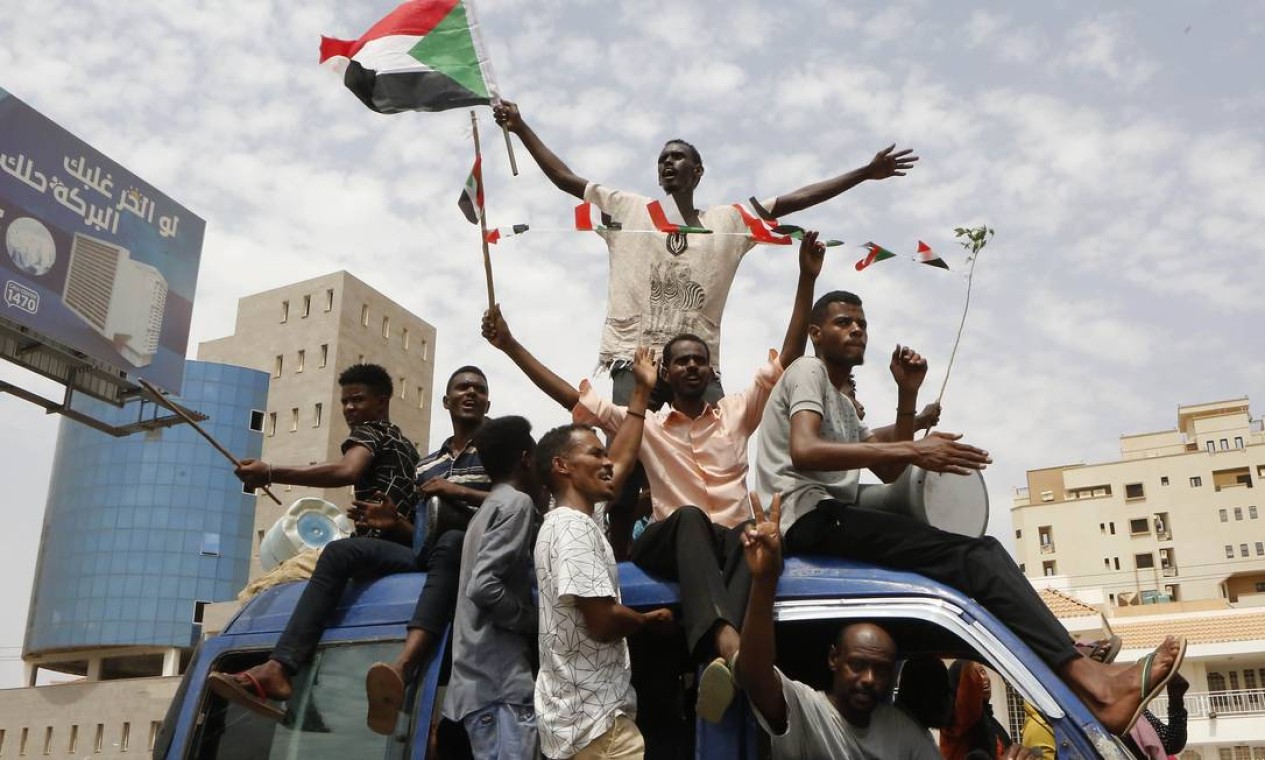 Manifestantes sudaneses comemoram nas ruas de Cartum o acordo, após meses de impasse, entre militares e civis para governo de transição no Sudão Foto: ASHRAF SHAZLY / AFP
