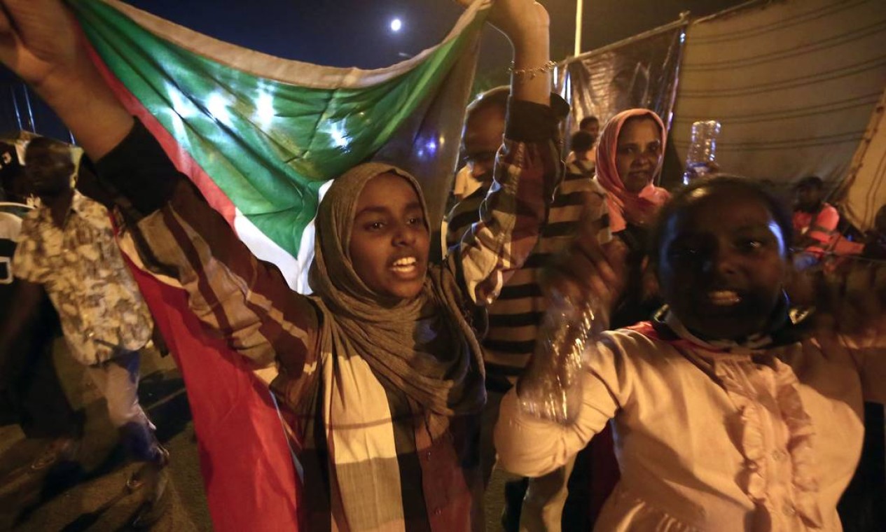 Sudaneses ocuparam as ruas para comemorar o fim do conflito, iniciado em dezembro de 2018. Até as eleições um general irá comandar o conselho rotativo pelos próximos 21 meses e, pelos 18 meses seguintes o cargo caberá a um civil Foto: ASHRAF SHAZLY / AFP