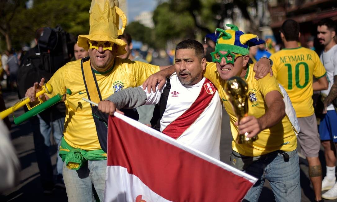 Torcedores do Brasil e do Peru posam juntos para foto no entorno do estádio do Maracanã, Rio de Janeiro, antes da partida final da Copa Amércia Foto: CARL DE SOUZA / AFP