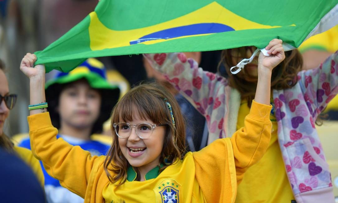 Pequena torcedora do Brasil segura bandeira nacional enquanto aguarda o início da partida final da Copa América no estádio do Maracanã Foto: LUIS ACOSTA / AFP