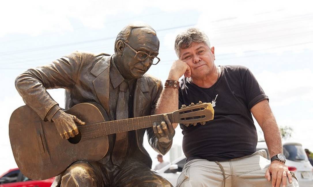 O músico Mauricio Dias, amigo de João Gilberto, com a estátua do cantor em Juazeiro Foto: Leo Sombra