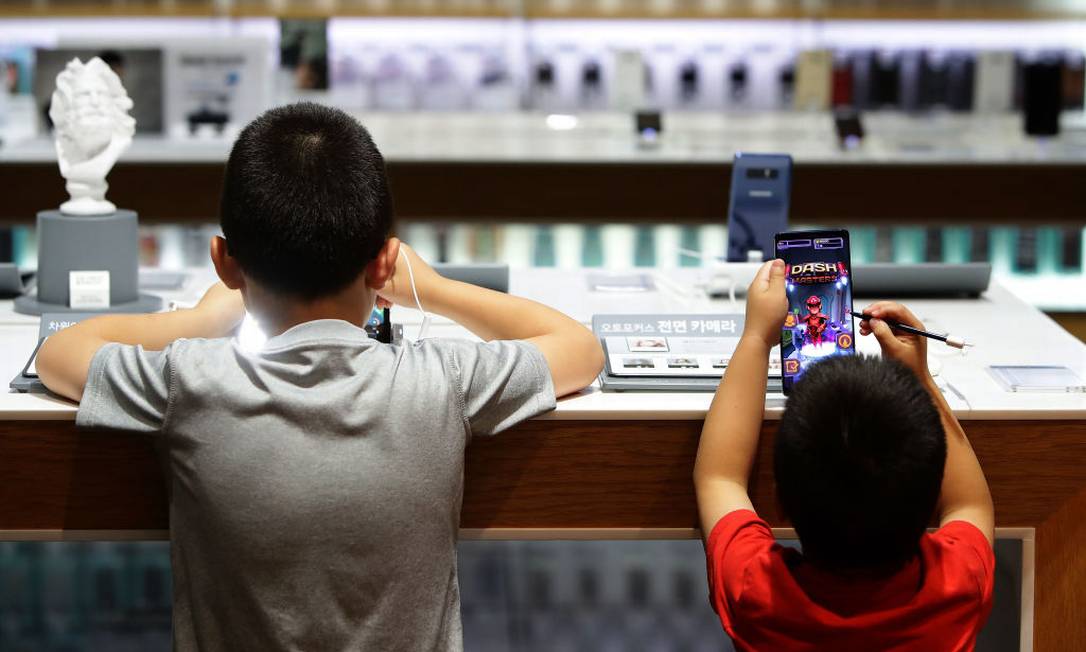 Crianças mexem em celulares na Coreia do Sul Foto: Chung Sung-Jun / Getty Images