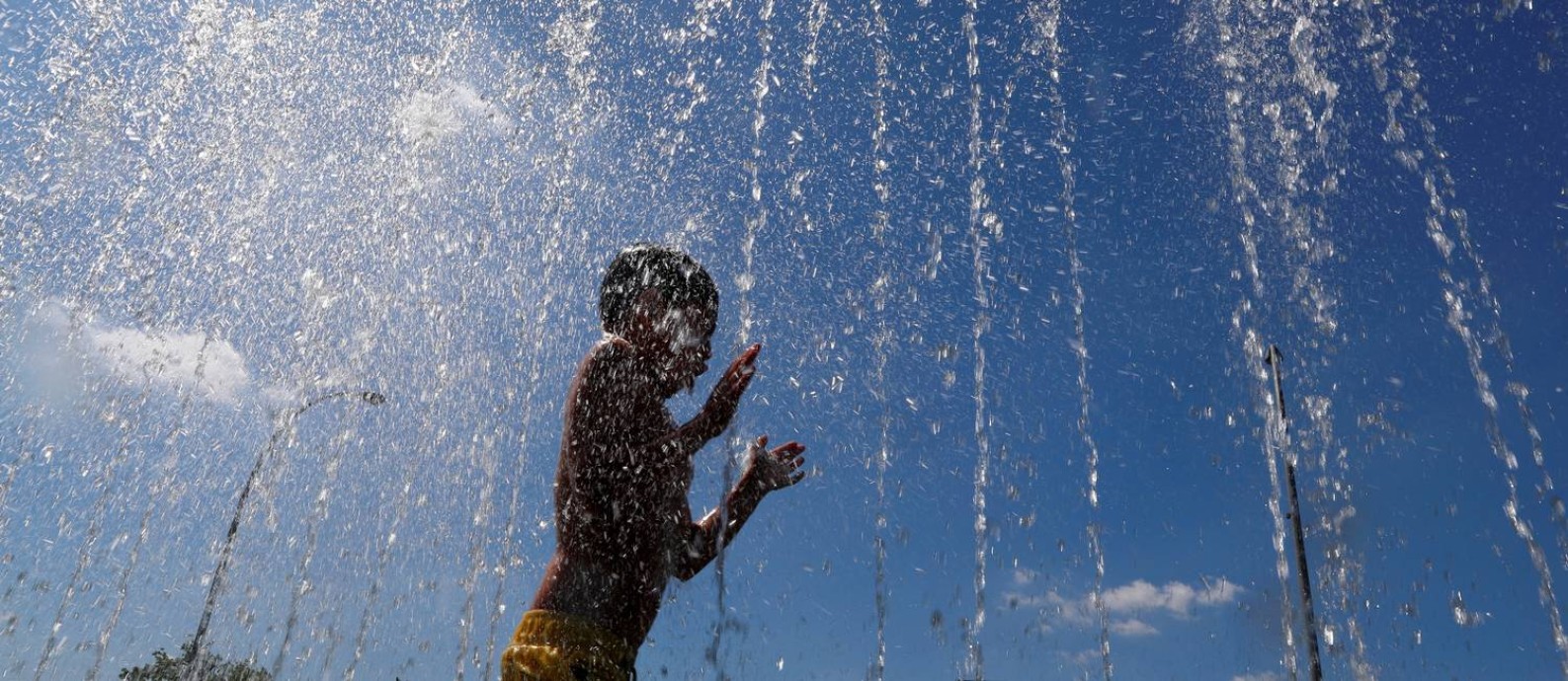 A child refreshes in a fountain next to the Chancellery during a hot summer day in Berlin, Germany, July 23, 2019. REUTERS/Fabrizio Bensch Foto: FABRIZIO BENSCH / REUTERS