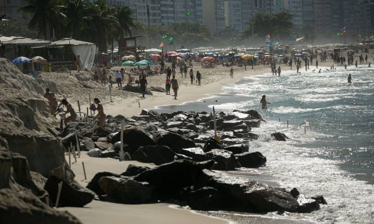 Apenas um pequeno espaço lotado de pedras separa o mar dos quiosques do calçadão Foto: Brenno Carvalho / Agência O Globo