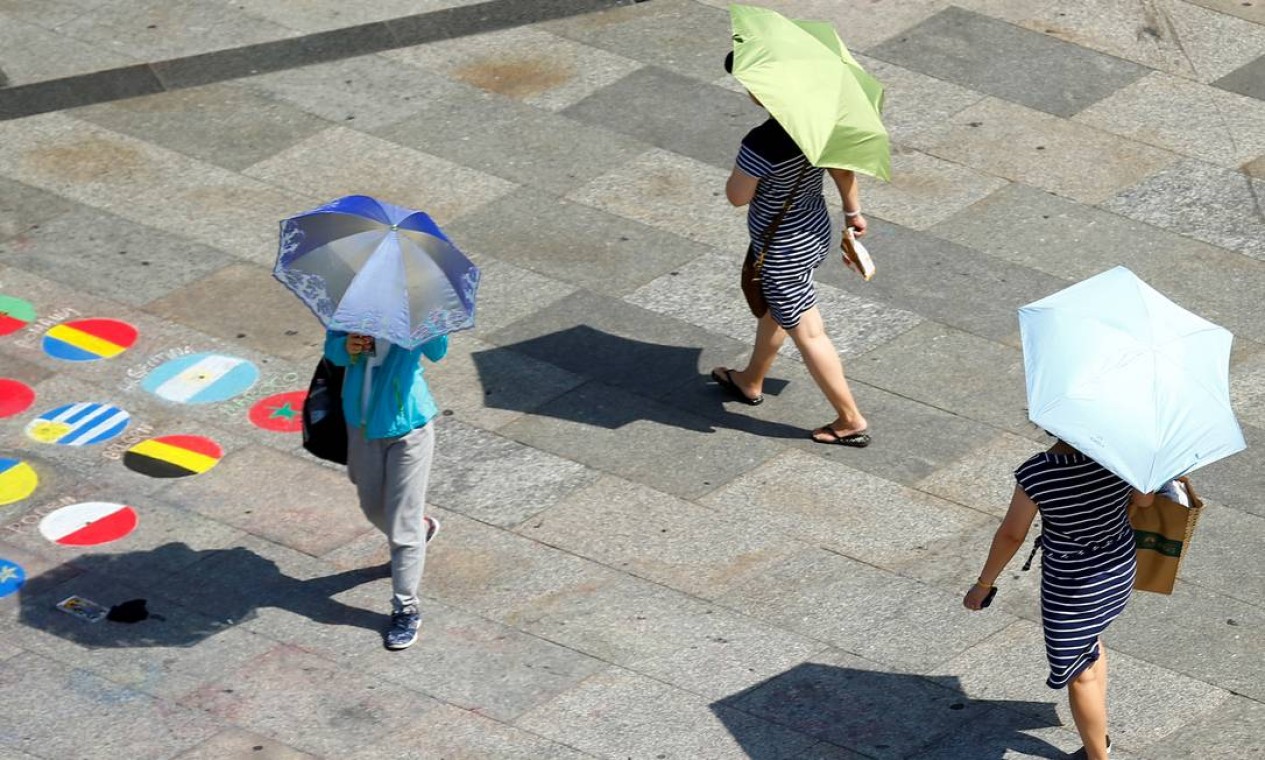 Em Colônia, Alemanha, o guarda-chuva está sendo usado para se proteger do sol. O Serviço Alemão de Meteorologia (DWD) registrou na quarta-feira (24) a temperatura mais alta já medida no país desde o início da análise em 1881. O registro foi na cidade de Geilenkirchen, na Renânia do Norte-Vestfália, onde os termômetros chegaram a 40,5°C Foto: THILO SCHMUELGEN / REUTERS