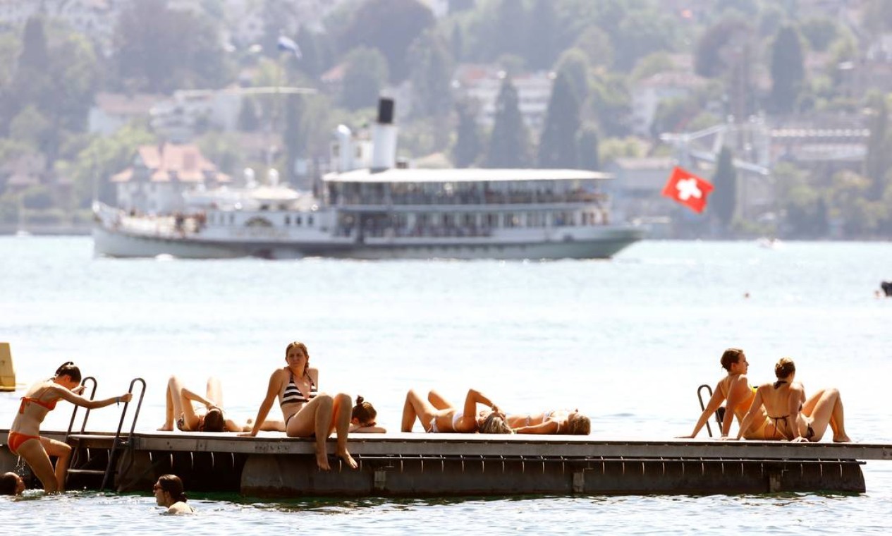 Navio turístico Rapperswil navega ao fundo enquanto banhistas relaxam em uma plataforma no Lago de Zurique, Suíça Foto: ARND WIEGMANN / REUTERS