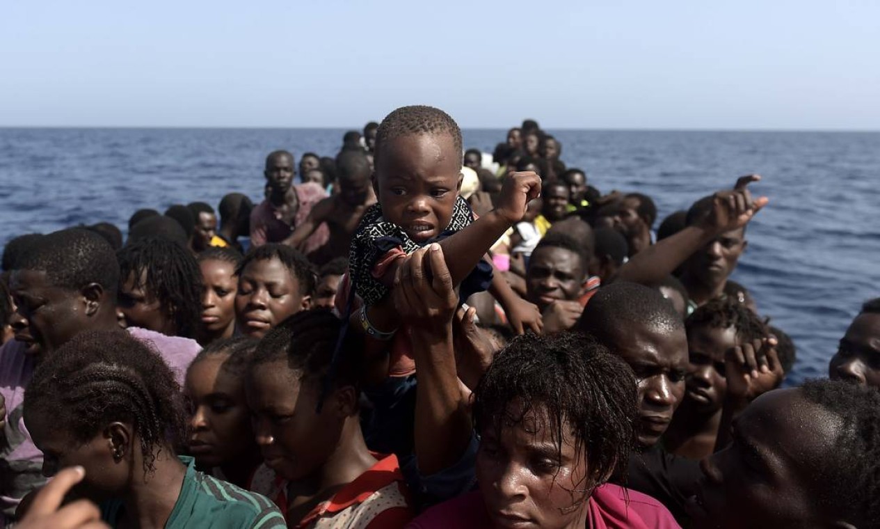 Imigrantes esperam ser resgatados por membros de ONG no Mar Mediterrâneo, cerca de 12 milhas náuticas ao norte da Líbia, em 4 de outubro de 2016 Foto: Aris Messinis / AFP