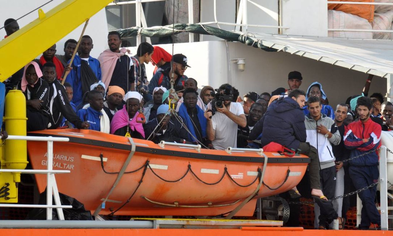 Imigrantes esperam para desembarcar do navio de resgate Aquarius, dirigido pela ONG "SOS Mediterranée", após uma operação de resgate no mar em 13 de outubro de 2017, em Palermo, na Sicília. Segundo a instituição, à epoca, mais de 600 imigrantes da Síria, Egito, Mali, Sudão, Marrocos, Argélia e Benin, entre eles 240 crianças, foram salvos no mar Mediterrâneo em menos 36 horas Foto: ALESSANDRO FUCARINI / AFP