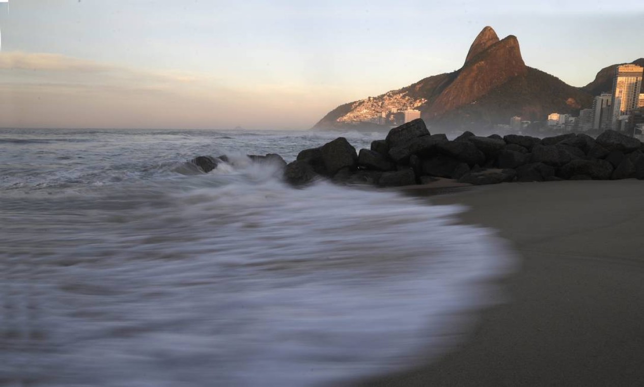 A luz captada nesta imagem mostra que o sol vem surgindo no amanhecer na Praia do Leblon Foto: Custódio Coimbra / Agência O Globo