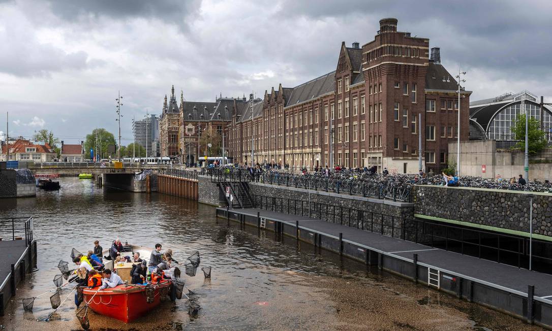 Turistas conhecem canais de Amsterdã pescando lixo Foto: Evert Elzinga/AFP / Evert Elzinga/AFP