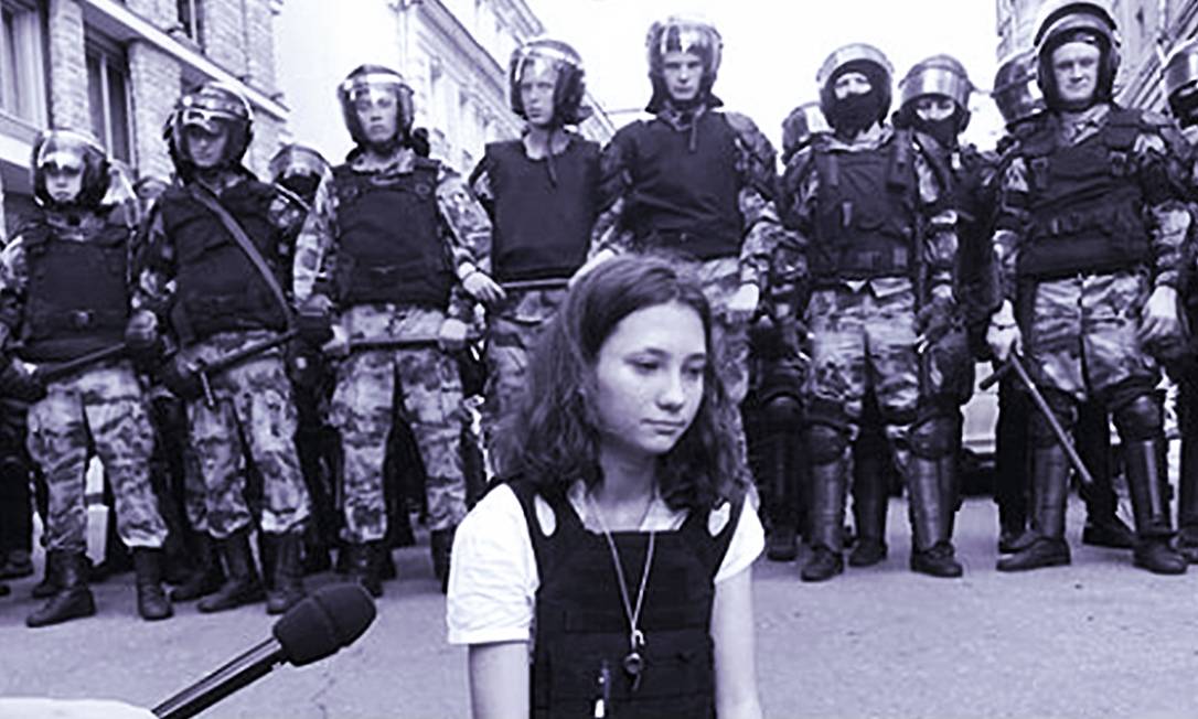 Olga sentada no chão durante protesto, bem à frente de policiais, com a constituição russa nas mãosentada no chão durante protesto, bem à frente de policiais, com a constituição russa nas mãos Foto: Reprodução do Instagram