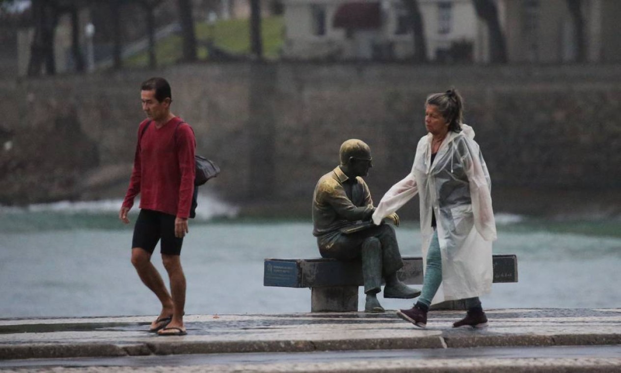 A caminhada da manhã teve que contar com uma capa de chuva Foto: Fabiano Rocha / Agência O Globo