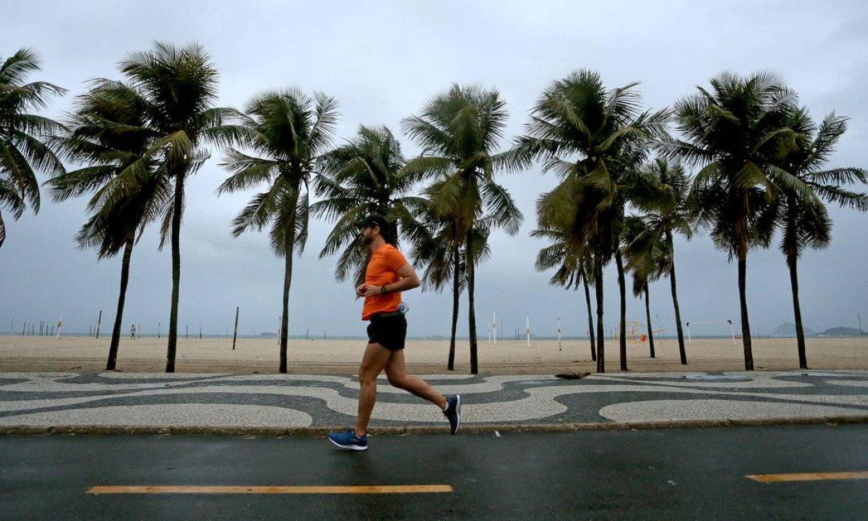 Chuva não atrapalha treino de corredor na orla de Copacabana Foto: Fabiano Rocha / Agência O Globo