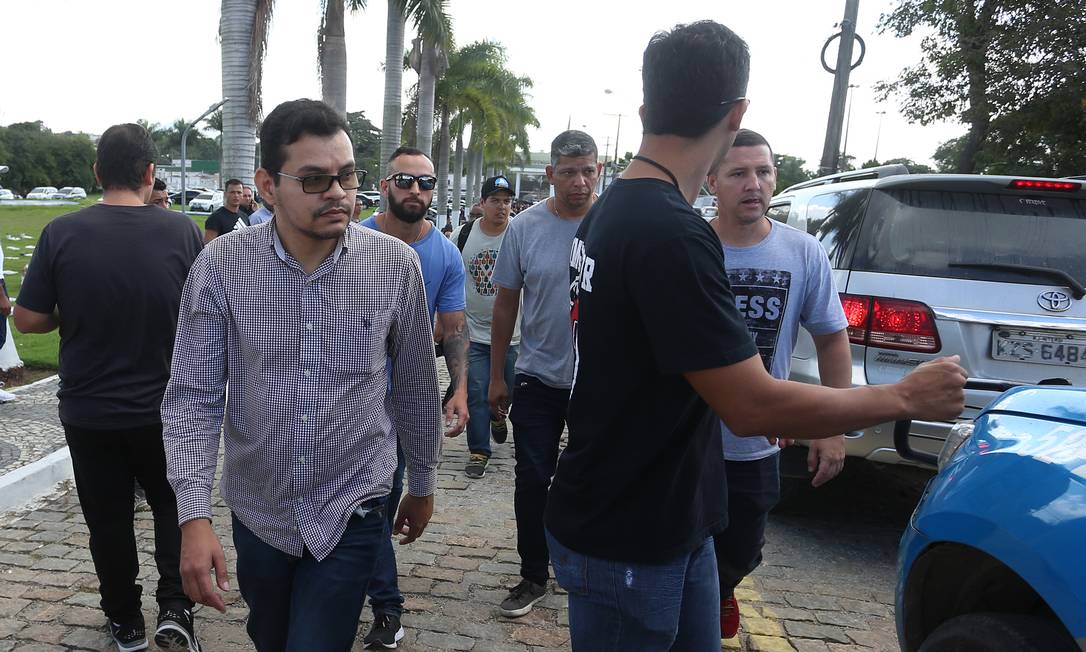 Flávio dos Santos Rodrigues, (de camisa de botão) é conduzido para a DH após o enterro em Anderson, em 17 de junho Foto: Fabiano Rocha / Agência O Globo