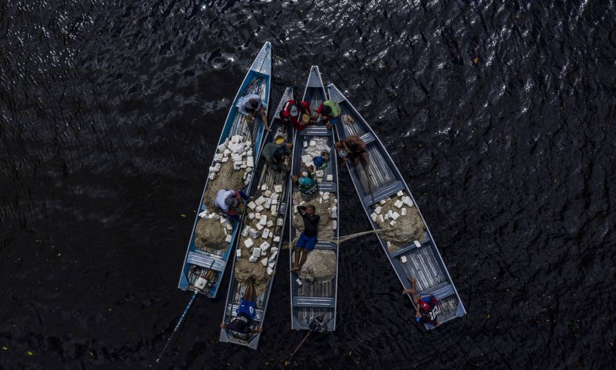 Indígenas do povo Paumari descansam, no intervalo para almoço, em pequenos barcos usados para a pesca do pirarucu Foto: Marizilda Cruppe