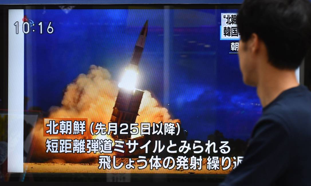 Pedestre observa notícia sobre novo teste de mísseis da Coreia do Norte, o sexto em menos de um mês. Pyongyang credita lançamentos aos exercícios militares realizados pelos EUA e Coreia do Sul. Foto: KAZUHIRO NOGI / AFP