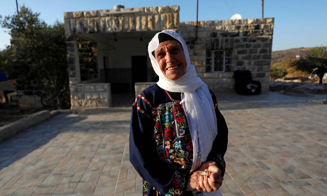Muftiya Tlaib, avó da deputada Rashida Tlaib, em frente à casa da família na vila de Beit ur al-Fauqa, na Cisjordânia. Aos 90 anos, ela foi poupada pela família das idas e vindas da tentativa da neta de visitá-la. Foto: MOHAMAD TOROKMAN / REUTERS