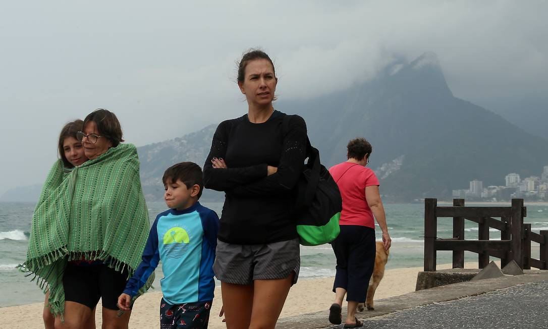 Família se protege do frio durante caminhada no Arpoador Foto: FABIANO ROCHA / Agência O Globo