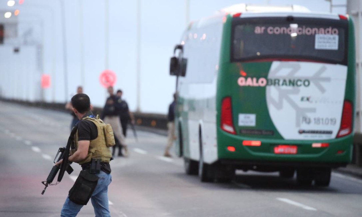 Policiais cercam o ônibus Foto: Fabiano Rocha / Agência O Globo